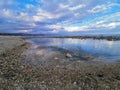 Beautiful stony shore with clear water under a cloudy sky