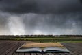 Beautiful stormy moody cloudy sky over English countryside landscape at dusk coming out of pages of open story book Royalty Free Stock Photo