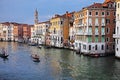 beautiful stratified buildings along the Venetian canal with gondolas and public water transport in Venice. Royalty Free Stock Photo