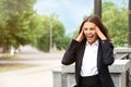 Beautiful stressed businesswoman outdoors