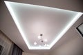 A beautiful stretch ceiling with diode lighting and an unusual chandelier with balls. Designer modern ceiling