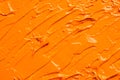 Beautiful strokes of orange oil paint as background, closeup