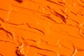 Beautiful strokes of orange oil paint as background, closeup