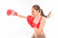 Beautiful strong sportswoman in red boxing gloves striking, side view photo Royalty Free Stock Photo