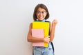 Beautiful student child girl wearing backpack glasses books over isolated white background screaming proud and celebrating victory Royalty Free Stock Photo