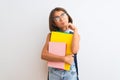 Beautiful student child girl wearing backpack glasses books over isolated white background serious face thinking about question, Royalty Free Stock Photo