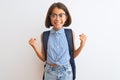 Beautiful student child girl wearing backpack and glasses over isolated white background celebrating surprised and amazed for Royalty Free Stock Photo