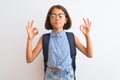 Beautiful student child girl wearing backpack and glasses over isolated white background relax and smiling with eyes closed doing Royalty Free Stock Photo