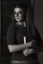 Beautiful student girl with book. young woman in red top and denim shorts with glasses Royalty Free Stock Photo