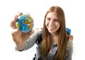 Beautiful student girl holding little world globe in her hand choosing holidays destination in travel tourism concept