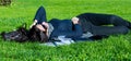 Beautiful student girl lying on green grass and relaxing Royalty Free Stock Photo