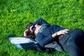 Beautiful student girl with notebooks lying on green grass and relaxing Royalty Free Stock Photo