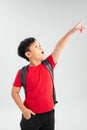 Beautiful student kid boy wearing backpack holding book over isolated white background very happy pointing with hand and finger to