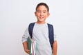 Beautiful student kid boy wearing backpack holding books over isolated white background with a happy face standing and smiling Royalty Free Stock Photo