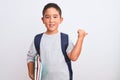 Beautiful student kid boy wearing backpack holding books over isolated white background pointing and showing with thumb up to the Royalty Free Stock Photo