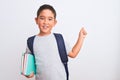 Beautiful student kid boy wearing backpack holding books over isolated white background very happy pointing with hand and finger Royalty Free Stock Photo