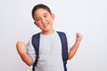 Beautiful student kid boy wearing backpack standing over isolated white background very happy and excited doing winner gesture Royalty Free Stock Photo