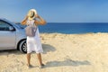 Beautiful stylish adult, mature woman  travels by car, with a hat and with a card in her hands, summer travel, freedom. Royalty Free Stock Photo
