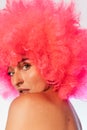 Woman wearing pink wig looking at camera over shoulder Royalty Free Stock Photo