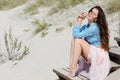 Beautiful and stylish brunette walking on the beach. Sitting on the stairs Royalty Free Stock Photo