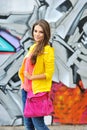 Beautiful stylish fashion woman at graffiti wall in city