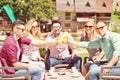 Beautiful stylish friends are using a digital tablet, drinking coffee and smiling while resting in the park Royalty Free Stock Photo