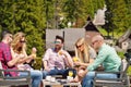 Beautiful stylish friends are using a digital tablet, drinking coffee and smiling while resting in the park Royalty Free Stock Photo