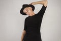 Beautiful stylish hipster woman in black hat and t-shirt, shirt fashion clothes, sad look, green eyes, isolated on white.