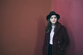 Beautiful stylish teenager girl in hat and red fur coat. Red calm sadness mood. problem solving. Fashion street style Royalty Free Stock Photo