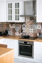 Beautiful stylish white real kitchen in Scandinavian style with wooden top and Spanish tiles