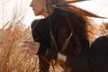 Beautiful stylish woman in black dress with boho accessories on a filed