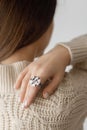 Beautiful stylish woman with modern round ring on hand with white  manicure, close up view Royalty Free Stock Photo