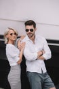 beautiful stylish young couple in sunglasses smiling at camera Royalty Free Stock Photo