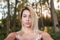 Beautiful stylish young woman blonde in a vintage pink striped dress resting in the woods on a sunny day Royalty Free Stock Photo