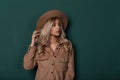 Beautiful stylish young woman with curly hair in an elegant beige vintage hat in a fashionable shirt with natural make-up posing Royalty Free Stock Photo