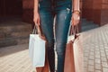Beautiful stylish young woman with shopping bags walking on city street in summer. Closeup of hands and purchases. Sale Royalty Free Stock Photo
