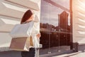 Beautiful stylish young woman with shopping bags walking on city street in summer. Happy girl holding purchases Royalty Free Stock Photo