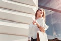 Beautiful stylish young woman with shopping bags walking on city street in summer. Happy girl holding purchases Royalty Free Stock Photo