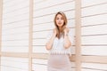 Beautiful stylish young woman in a vintage lace blouse with an ornament in a beige skirt with a brilliant necklace posing near a Royalty Free Stock Photo