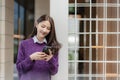 Beautiful successful asian businesswoman holding mobile phone using smartphone in office Royalty Free Stock Photo