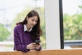 Beautiful successful asian businesswoman holding mobile phone using smartphone in office Royalty Free Stock Photo