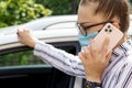 Beautiful successful prosperous rich business woman in white suit talking on phone wearing a medical mask standing near