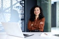 Beautiful and successful woman at work inside office, businesswoman smiling and looking at camera sitting at desk, using Royalty Free Stock Photo