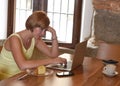 Beautiful successful woman working at coffee shop with laptop computer enjoying coffee cup Royalty Free Stock Photo