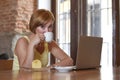 Beautiful successful woman working at coffee shop with laptop computer enjoying coffee cup Royalty Free Stock Photo