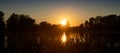 Beautiful summer autumn landscape, the sun sets in the forest, a view of the trees and grass pond, reflected in the water.