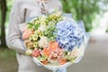 Beautiful summer bouquet. Arrangement with mix flowers. Young girl holding a flower arrangement with hydrangea. The Royalty Free Stock Photo