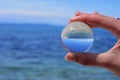 Beautiful summer coast seen through a blue glass ball/ Blue freedom concept/ Ocean Surface Ripples and Clouds in Sky Captured in G Royalty Free Stock Photo