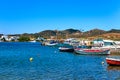 Beautiful summer day on Greek island, Milos, Greece. Fishing boats at jetty. Whitewashed houses, Mediterranean lifestyle