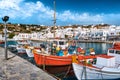 Beautiful summer day in marina of Greek island. Colorful fishing boats. Whitewashed houses. Mykonos, Cyclades, Greece.